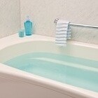 温かいお湯の入った浴槽と、きれいに配置されたタオルやバス用品。