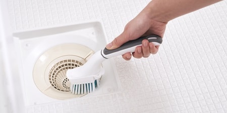 ハンディブラシを使用して排水口を掃除するシーン
