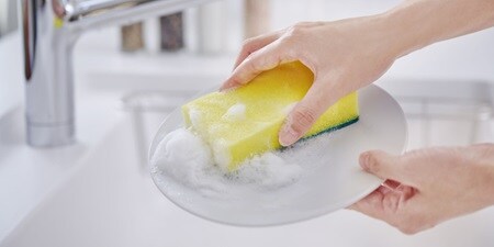 抗菌ウレタンスポンジたわしで皿を洗うシーン
